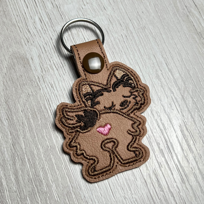 Embroidered keychain of a brown Yorkie dog butt